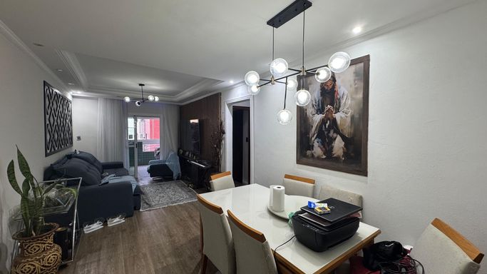 Sala de 2 ambientes com lustre pendente e ar-condicionado.