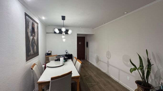 Sala de 2 ambientes com lustre pendente e ar-condicionado.
