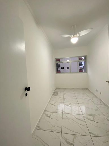 Sala com piso reformado com ventilador de teto e uma janela grande.
