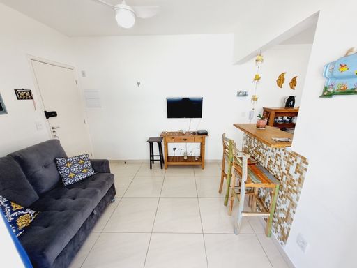 Sala bem iluminada com um sofá e sacada.