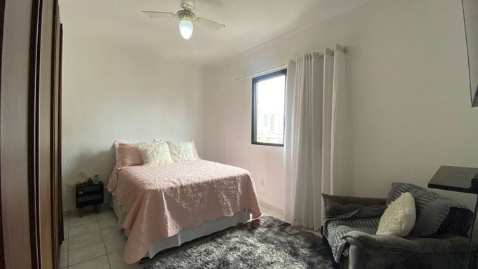 Dormitório bem iluminado com um ventilador de teto.