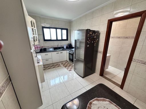 Cozinha ampla e bem iluminada com uma mesa de granito.