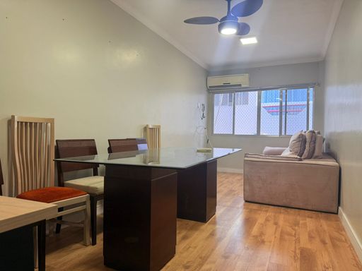 Sala de 2 ambientes com uma mesa de jantar, sofá, ventilador de teto e ar-condicionado.