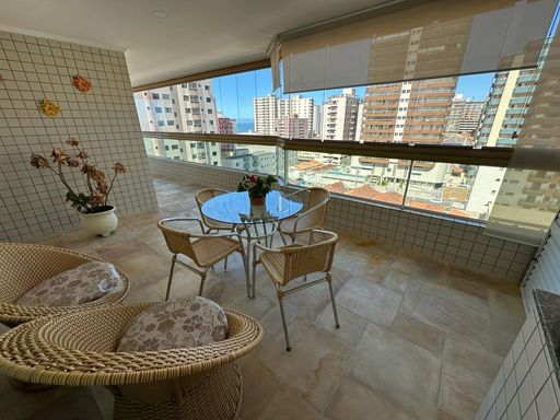 Sacada gourmet envidraçada com vista para o mar.