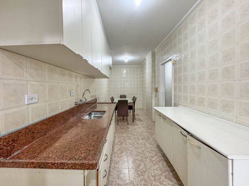 Cozinha ampla com armários planejados e mesa de jantar de 6 lugares.