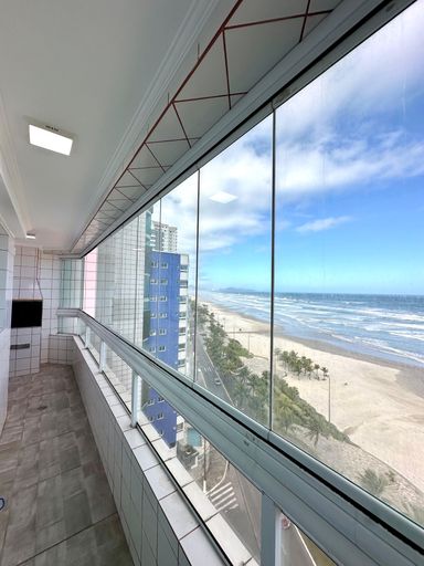 Sacada gourmet envidraçada com vista para o mar.