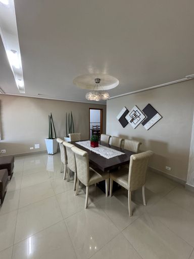 Sala ampla de 2 ambientes com sofá, mesa de jantar e ar-condicionado.
