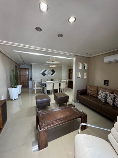 Sala ampla de 2 ambientes com sofá, mesa de jantar e ar-condicionado.