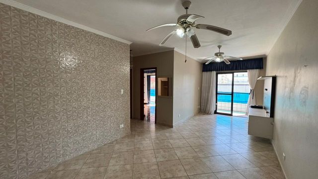 Sala ampla e bem iluminada de 2 ambientes com 2 ventiladores de teto.