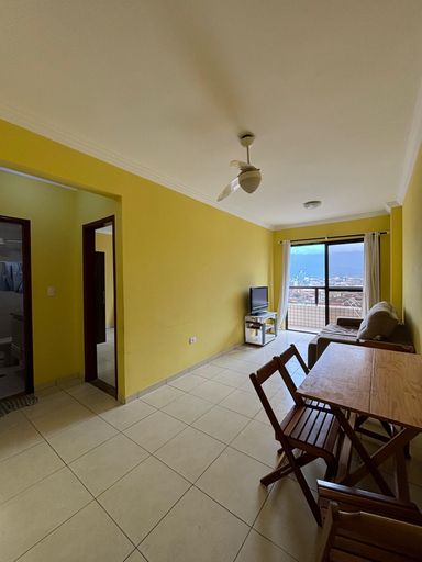 Sala de 2 ambientes com paredes amarelas, mesa, sofa e ventilador de teto.