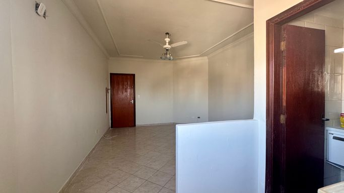 Sala living bem iluminado com ventilador de teto.