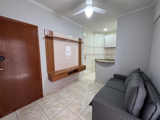 Sala com ventilador de teto e sofá.