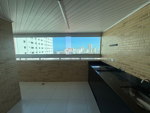 Sacada envidraçada com vista para o mar.
