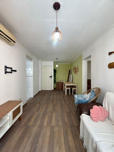 Sala ampla e bem iluminada com ar-condicionado e uma janela com vista para o mar.