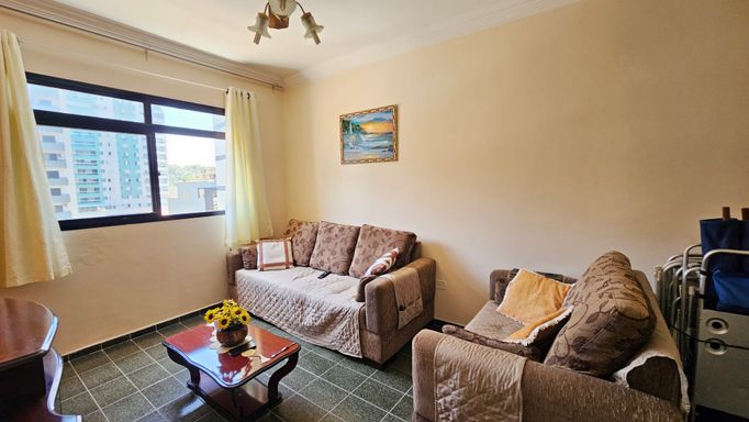 Sala ampla e bem iluminada com ventilador de teto e dois sofás.