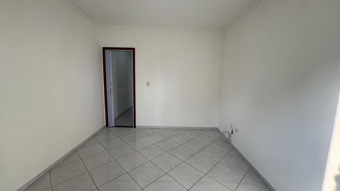 Dormitório espaçoso e com muita iluminação natural com sacada.