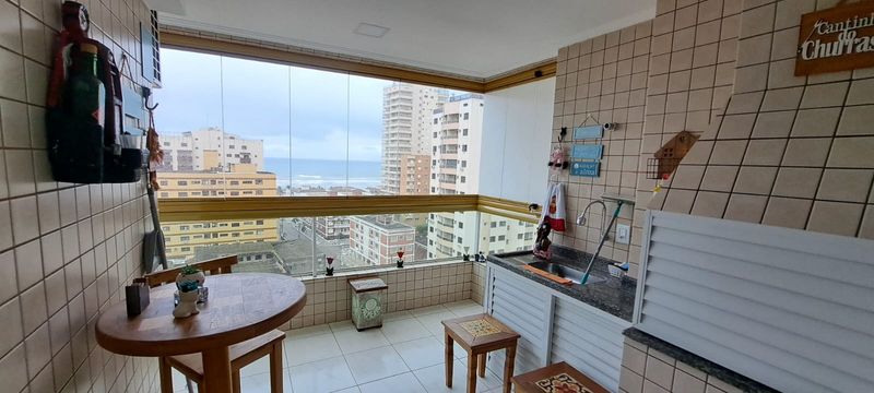 Sacada gourmet envidraçada com vista para o mar.