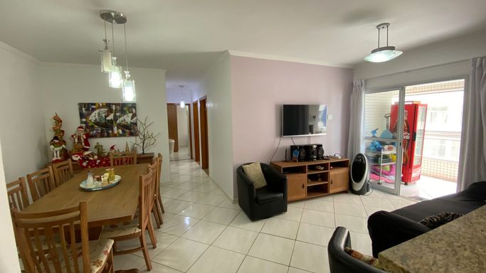 Sala de 2 ambientes com uma mesa de jantar e sofá.