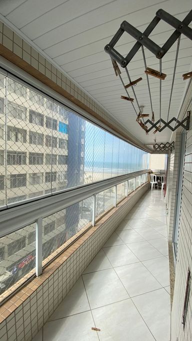 Sacada gourmet envidraçada com vista para o mar.