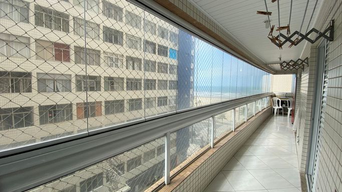 Sacada gourmet envidraçada com vista para o mar.