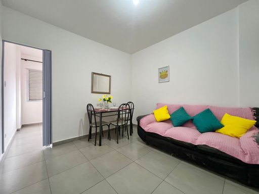 Sala com sofá de 3 lugares e mesa de jantar.