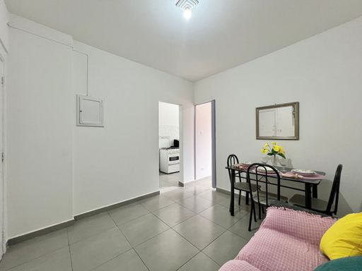 Sala com sofá de 3 lugares e mesa de jantar.