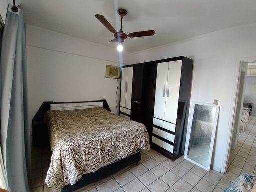 Dormitório amplo e bem iluminado com uma sacada privativa e ventilador de teto.