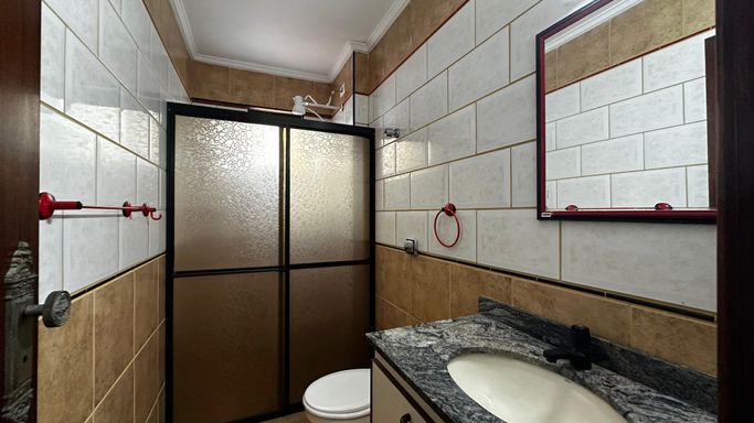 WC social com uma pia e gabinete.