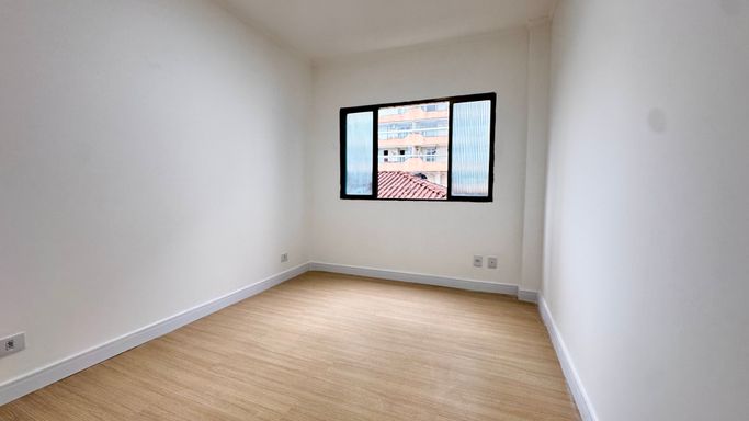 Sala bem iluminado com piso laminado.