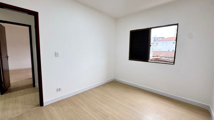Suíte bem iluminado com piso laminado.