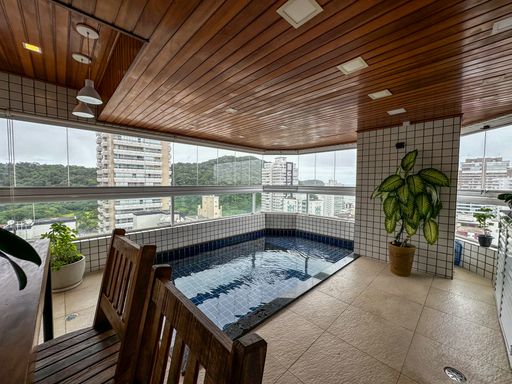 Sacada envidraçada com vista para o mar com piscina, churrasqueira a gás.
