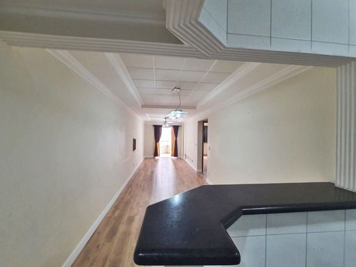 Sala ampla e bem iluminada e cozinha americana.