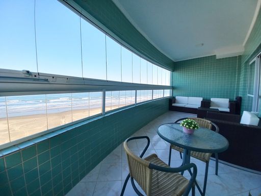 Sacada envidraçada com vista para o mar.