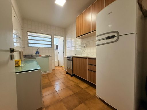 Cozinha com armários e uma geladeira branca.