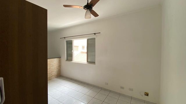Sala living com uma guarda-roupa e dois ventilador de teto.