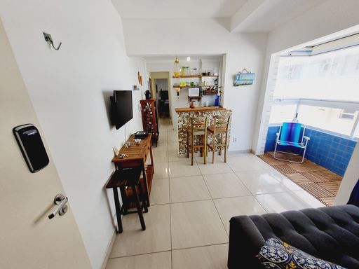 Sala bem iluminada com um sofá e sacada.