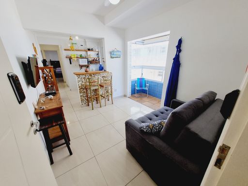 Sala bem iluminada com um sofá e sacada.