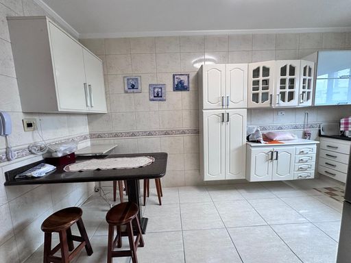 Cozinha ampla e bem iluminada com uma mesa de granito.