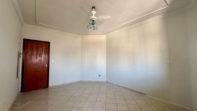 Sala living bem iluminado com ventilador de teto.