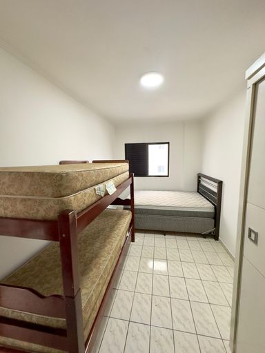 Dormitório amplo com uma cama de casal e beliche.