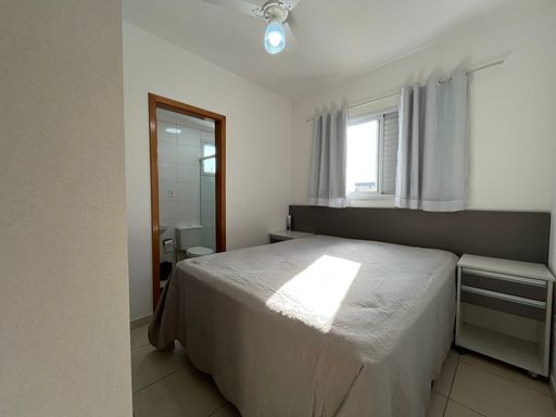 Suíte planejada com uma cama de casal e ventilador de teto.