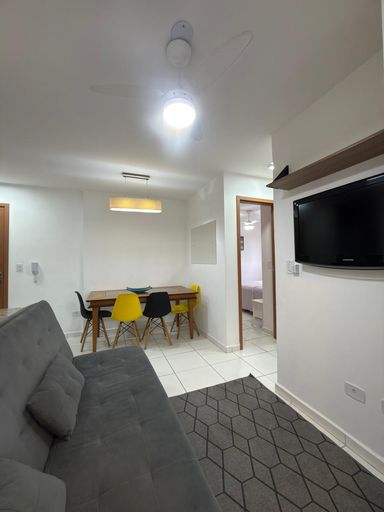 Sala com uma mesa de jantar e sofá cama.