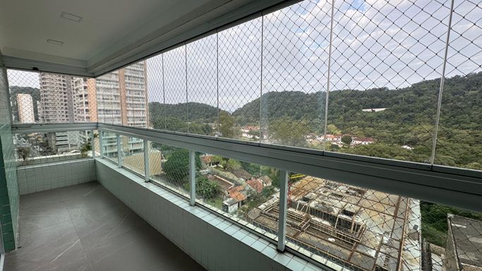 Sacada gourmet envidraçada com vista para a montanha.