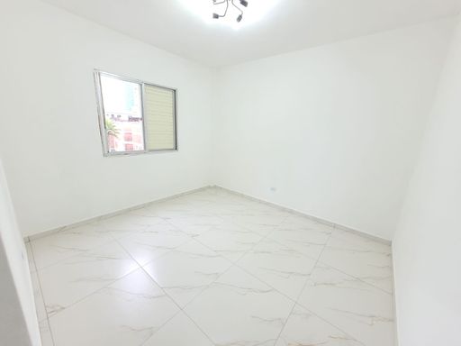Dormitório espaçoso e bem iluminado com piso em porcelanato.