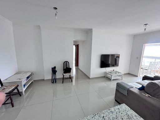 Sala de 2 ambientes com muita iluminação natural e sofá e ar-condicionado.