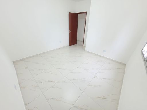 Dormitório espaçoso e bem iluminado com piso em porcelanato.