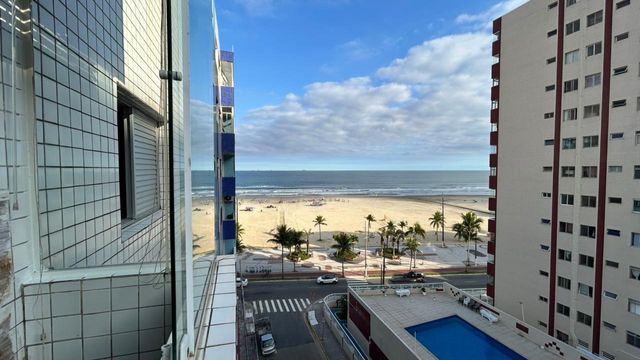 Sacada envidraçada com vista para o mar.