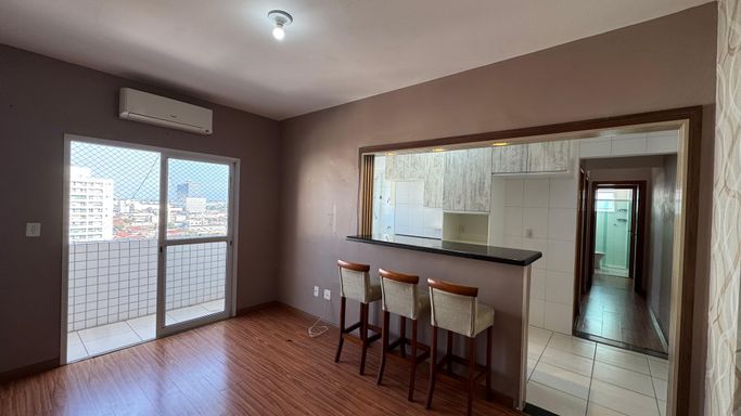 Sala espaçosa com muita iluminação natural, piso laminado, ar-condicionado e acesso a sacada.