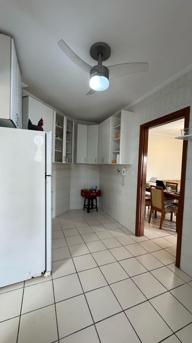 Cozinha ampla com armários, geladeira e fogão.