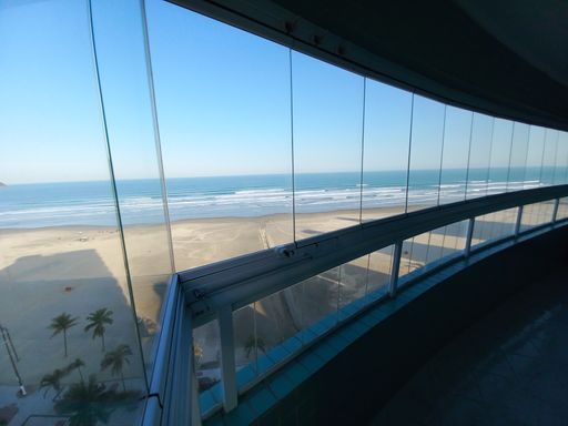 Sacada envidraçada com vista para o mar.